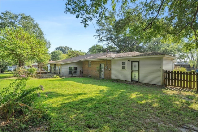 rear view of house featuring a yard