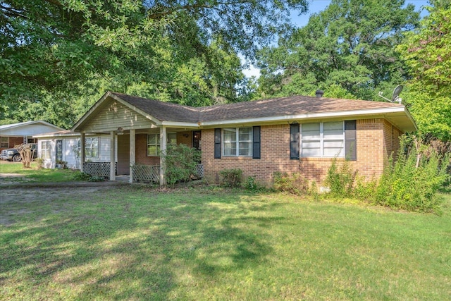 single story home with covered porch and a front yard