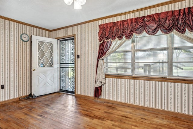 entrance foyer with ornamental molding, wood-type flooring, and a textured ceiling