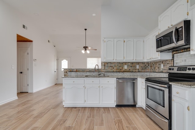 kitchen featuring white cabinetry, backsplash, appliances with stainless steel finishes, and sink