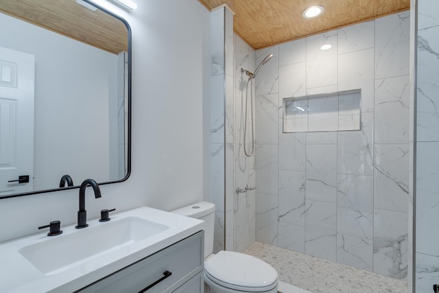 bathroom featuring tiled shower, toilet, and vanity