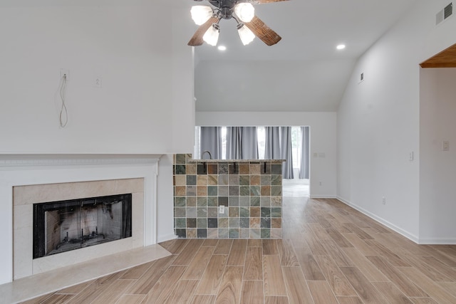 unfurnished living room with high vaulted ceiling, light wood-type flooring, and ceiling fan