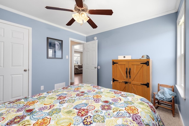 bedroom featuring carpet floors, ceiling fan, and crown molding