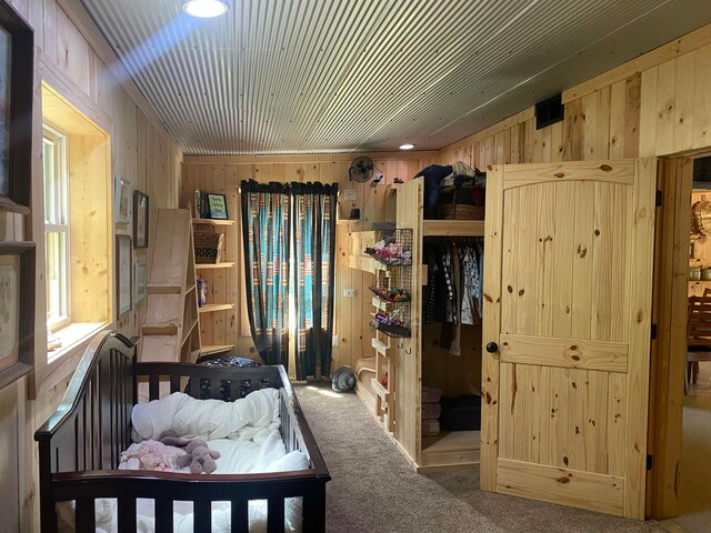 carpeted bedroom with wooden walls