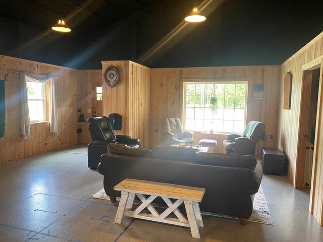 living room featuring wooden walls and high vaulted ceiling