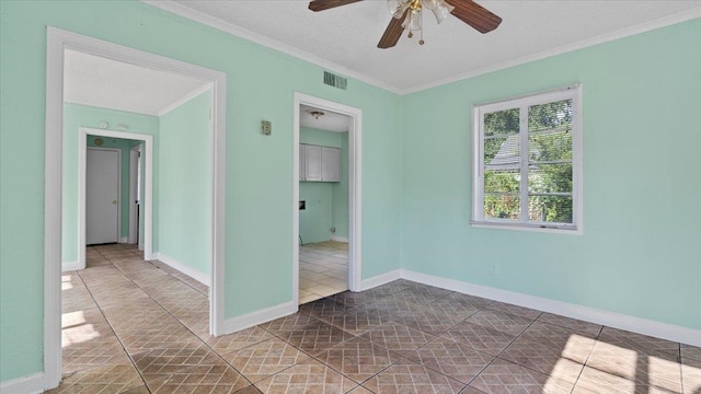 empty room featuring ornamental molding, ceiling fan, tile patterned floors, and a textured ceiling