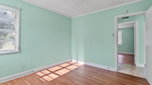 tiled spare room with ornamental molding and a textured ceiling