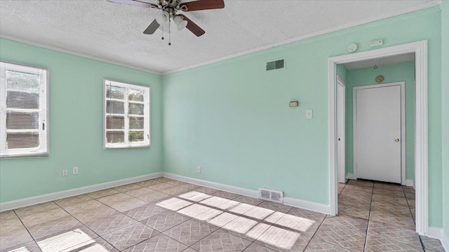 tiled empty room with a textured ceiling, ceiling fan, and crown molding