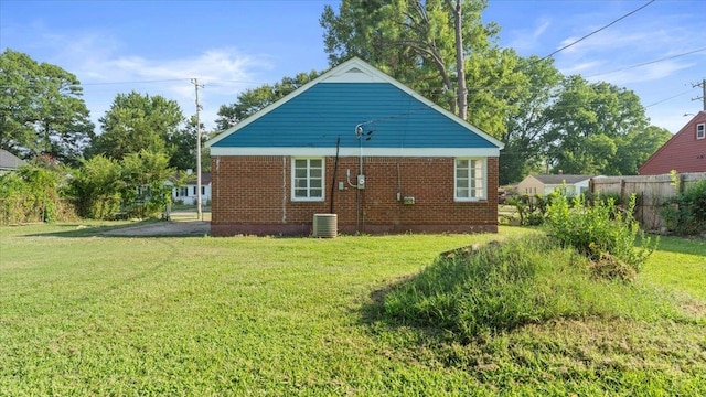 back of property with cooling unit and a lawn