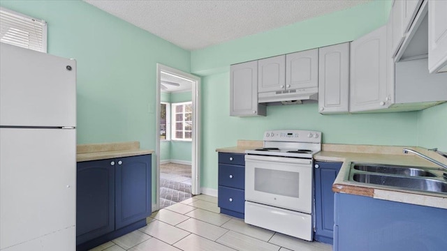 kitchen with sink, light tile patterned floors, white cabinets, and white appliances