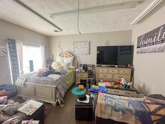 bedroom with dark hardwood / wood-style flooring and a textured ceiling