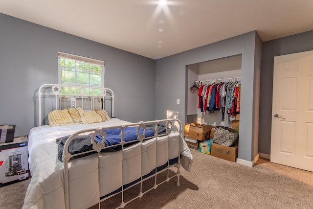 carpeted bedroom with a closet, a spacious closet, and baseboards