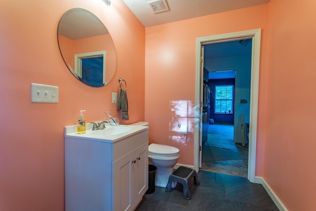 bathroom with baseboards, visible vents, vanity, and toilet