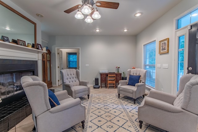 living room featuring light tile patterned floors, ceiling fan, recessed lighting, baseboards, and a glass covered fireplace