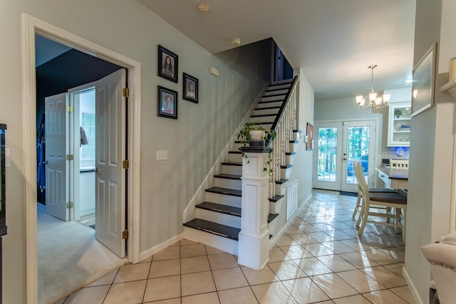 staircase with tile patterned flooring, french doors, baseboards, and an inviting chandelier