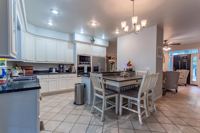 dining room featuring ceiling fan with notable chandelier and light tile patterned floors