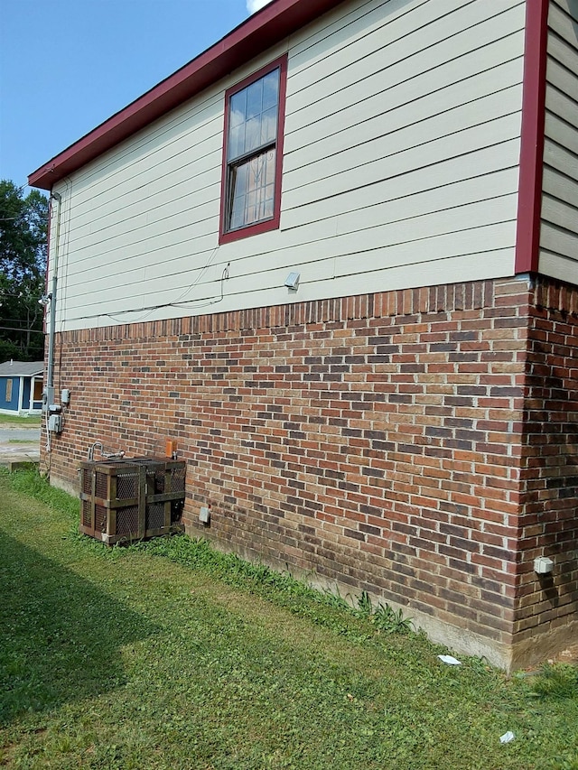 view of side of property with cooling unit and a lawn