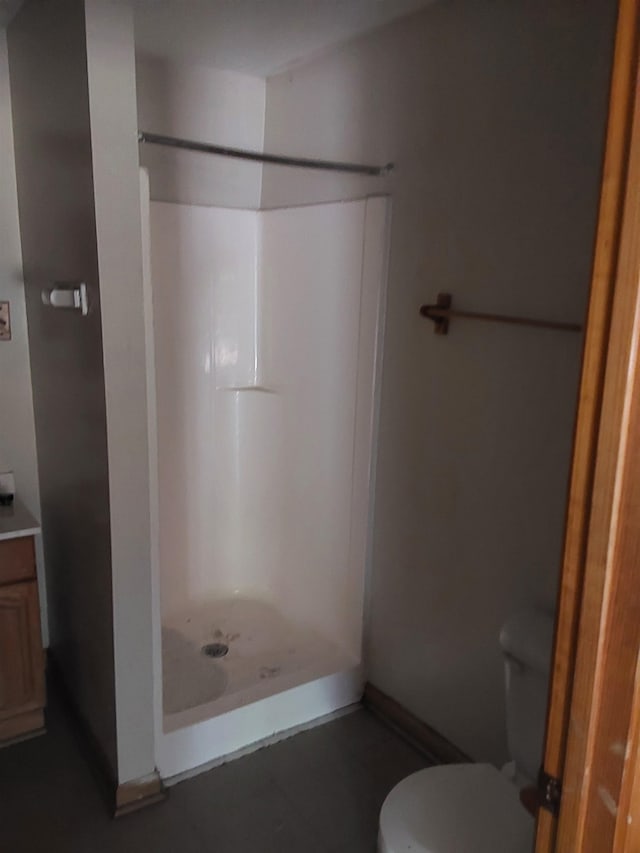 bathroom with a shower, vanity, tile patterned flooring, and toilet