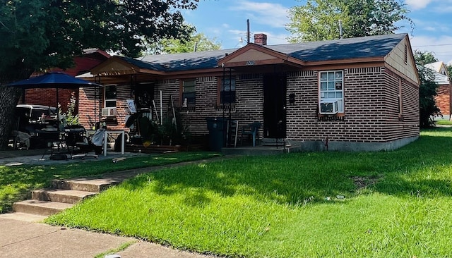 exterior space featuring entry steps, brick siding, a chimney, and a front yard