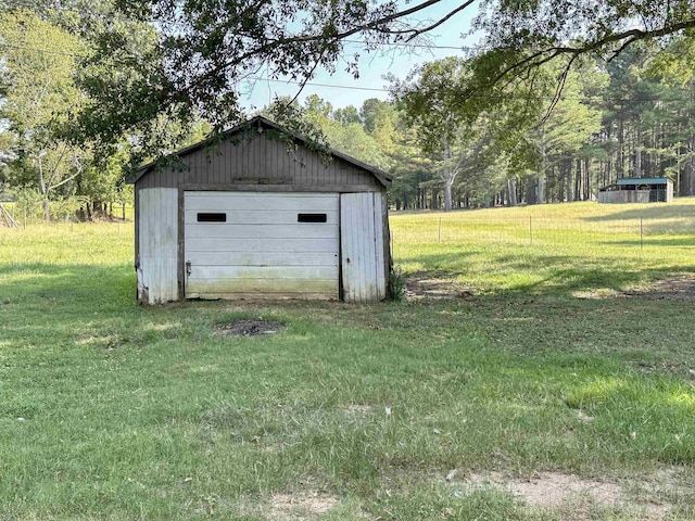 view of outdoor structure with a yard and a garage