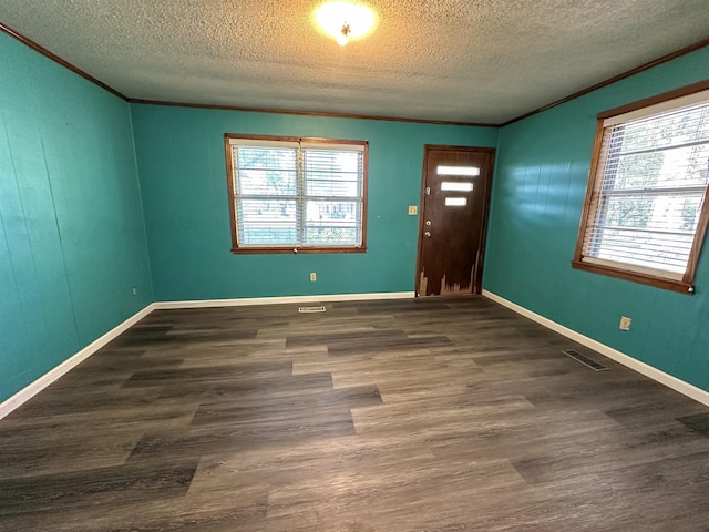 foyer entrance with ornamental molding, plenty of natural light, and dark wood-type flooring