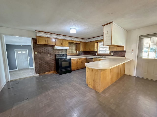 kitchen featuring black electric range oven, sink, plenty of natural light, and kitchen peninsula