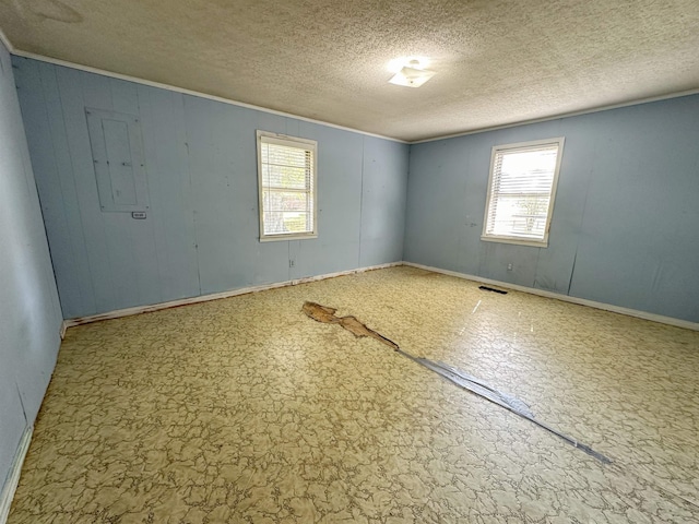 empty room with crown molding and a textured ceiling