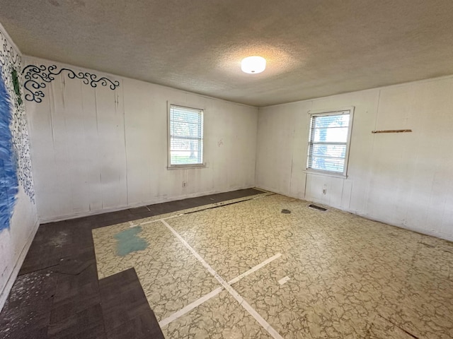 unfurnished room featuring plenty of natural light and a textured ceiling