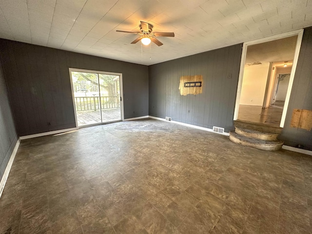 interior space featuring wooden walls and ceiling fan