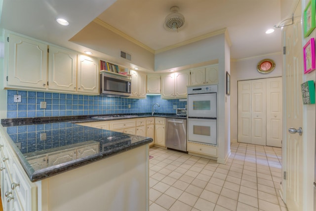 kitchen with visible vents, a peninsula, ornamental molding, stainless steel appliances, and backsplash
