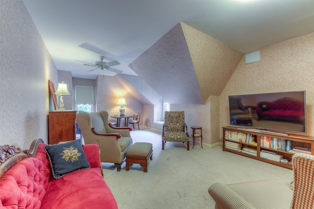 living area featuring carpet, baseboards, wallpapered walls, a ceiling fan, and lofted ceiling