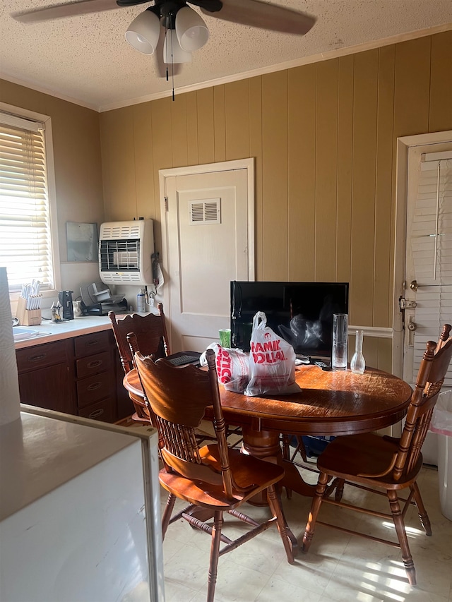 tiled dining room with ceiling fan and a textured ceiling