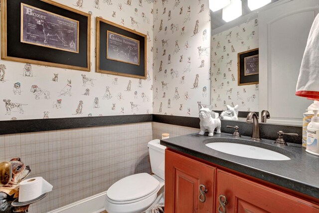 bathroom with vanity, tile walls, and toilet