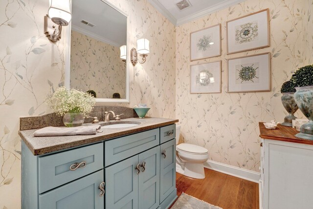 bathroom featuring vanity, toilet, hardwood / wood-style flooring, and ornamental molding