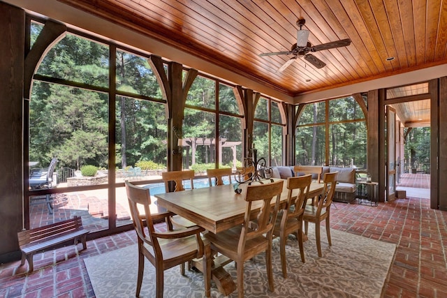 sunroom / solarium with ceiling fan, plenty of natural light, and wood ceiling