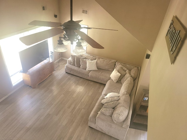 living room featuring high vaulted ceiling, light hardwood / wood-style floors, and ceiling fan