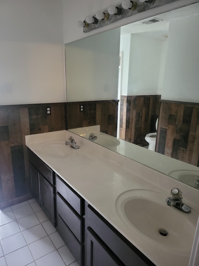 bathroom featuring vanity, tile patterned floors, toilet, and wood walls