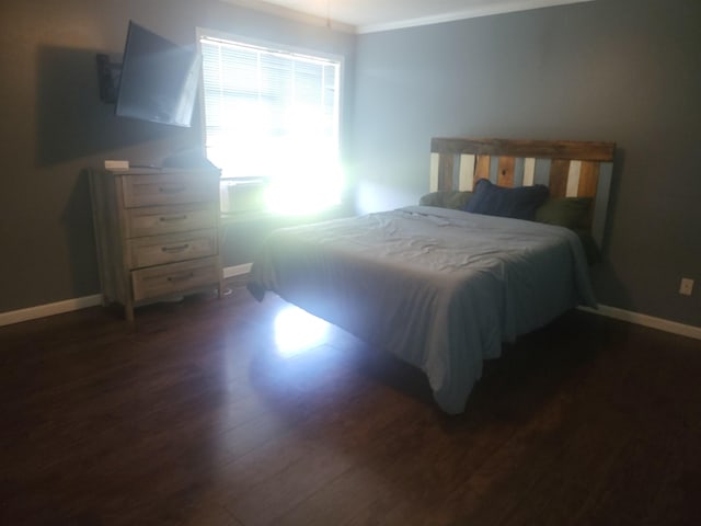 bedroom with crown molding and dark hardwood / wood-style floors