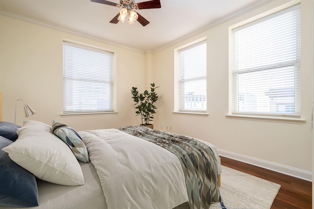 bedroom featuring ceiling fan, ornamental molding, and dark hardwood / wood-style floors