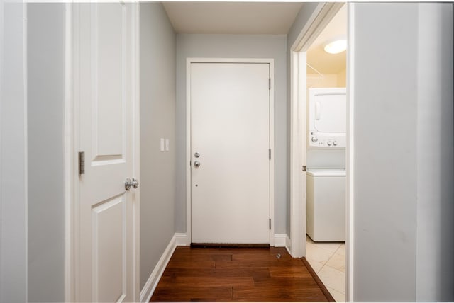 doorway to outside featuring stacked washer and dryer and dark wood-type flooring