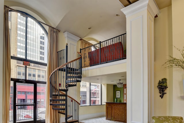 staircase featuring a towering ceiling and a wealth of natural light