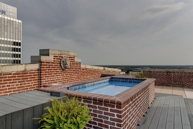 view of swimming pool with an outdoor hot tub