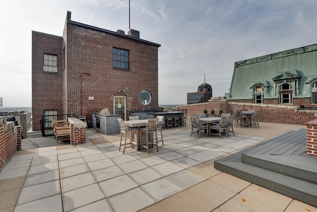 view of patio with an outdoor kitchen, exterior bar, and a fireplace