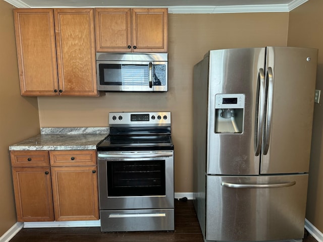 kitchen with appliances with stainless steel finishes, dark hardwood / wood-style flooring, and ornamental molding