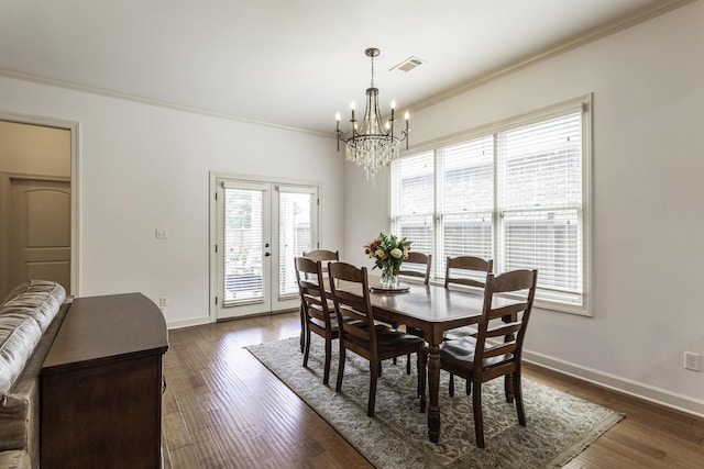 dining space with french doors, ornamental molding, dark hardwood / wood-style floors, and a chandelier