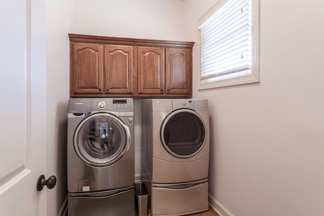 washroom with cabinets and washer and dryer