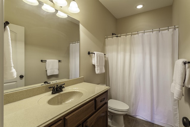 bathroom featuring vanity, tile patterned floors, and toilet