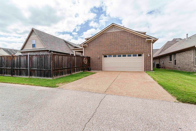 view of front facade with a front yard, a garage, and central AC