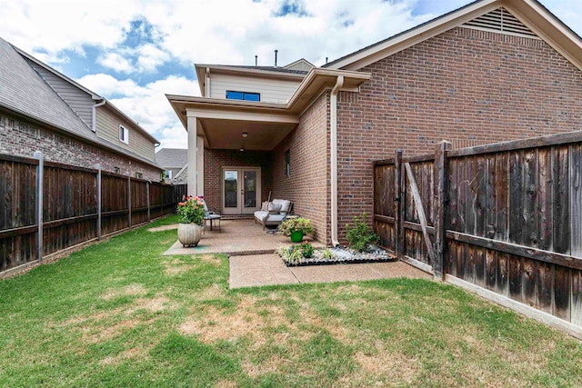 back of property featuring french doors, a lawn, and a patio area