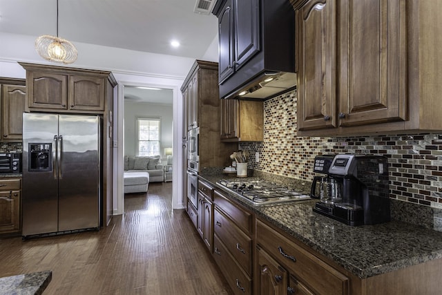 kitchen with backsplash, dark hardwood / wood-style flooring, dark stone counters, dark brown cabinetry, and stainless steel appliances